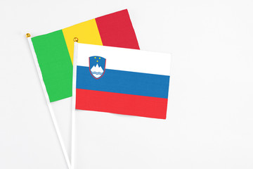 Slovenia and Mali stick flags on white background. High quality fabric, miniature national flag. Peaceful global concept.White floor for copy space.