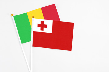 Tonga and Mali stick flags on white background. High quality fabric, miniature national flag. Peaceful global concept.White floor for copy space.