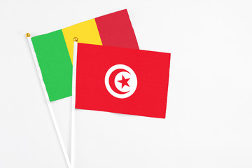 Tunisia and Mali stick flags on white background. High quality fabric, miniature national flag. Peaceful global concept.White floor for copy space.