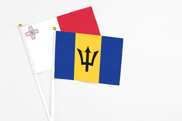 Barbados and Malta stick flags on white background. High quality fabric, miniature national flag. Peaceful global concept.White floor for copy space.