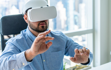 Man working in VR goggles in office © BullRun