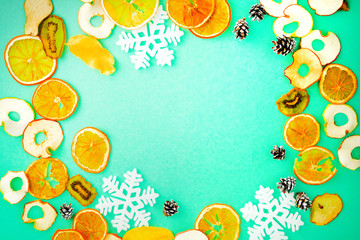 Fototapeta na wymiar Christmas composition. Fruits, Snowflakes, Fir Cones on green background. Citrus winter holiday. Flat lay, top view, copy space.