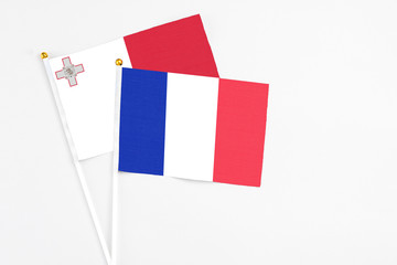 France and Malta stick flags on white background. High quality fabric, miniature national flag. Peaceful global concept.White floor for copy space.