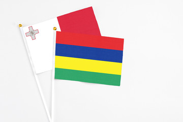 Mauritius and Malta stick flags on white background. High quality fabric, miniature national flag. Peaceful global concept.White floor for copy space.