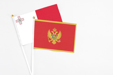 Montenegro and Malta stick flags on white background. High quality fabric, miniature national flag. Peaceful global concept.White floor for copy space.