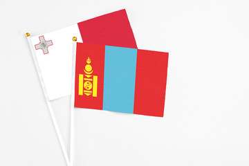Mongolia and Malta stick flags on white background. High quality fabric, miniature national flag. Peaceful global concept.White floor for copy space.
