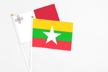 Myanmar and Malta stick flags on white background. High quality fabric, miniature national flag. Peaceful global concept.White floor for copy space.