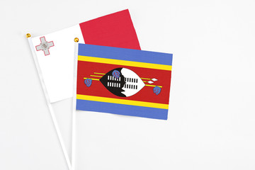 Swaziland and Malta stick flags on white background. High quality fabric, miniature national flag. Peaceful global concept.White floor for copy space.