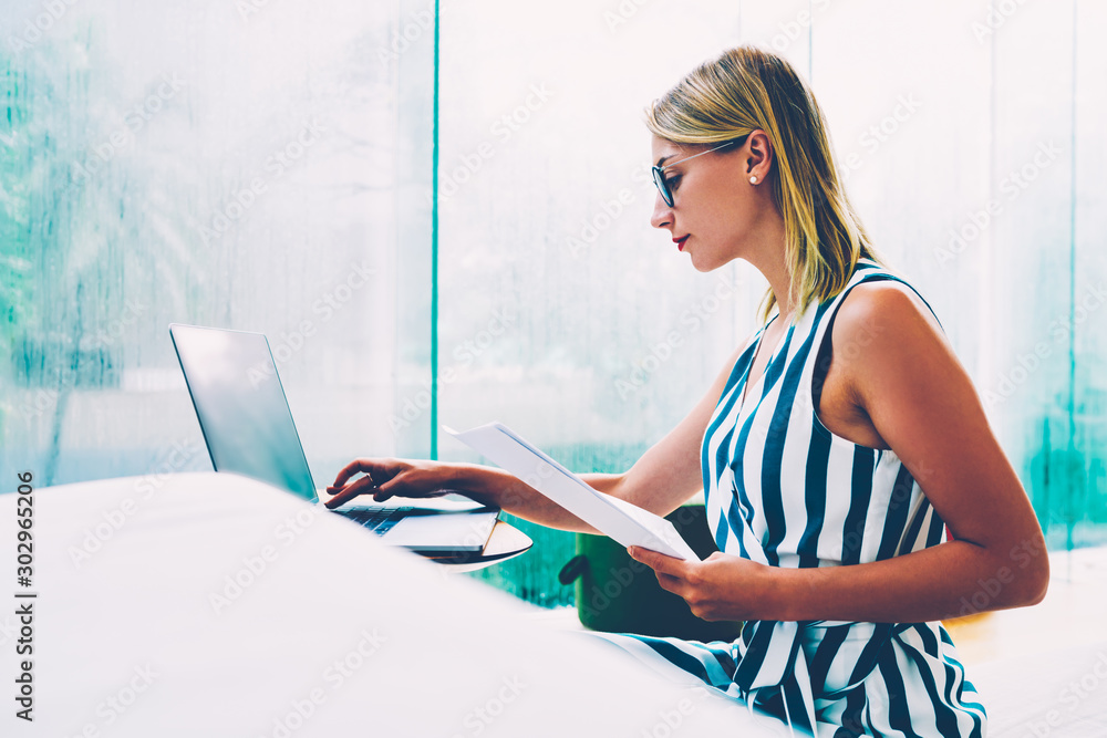Poster side view of stylish student in eyeglasses typing text information from coursework on modern laptop 