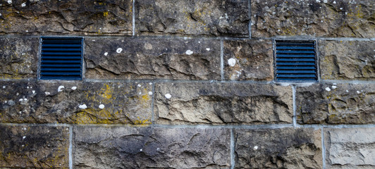Old brick wall with two air vents