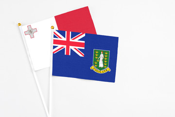 Fototapeta premium British Virgin Islands and Malta stick flags on white background. High quality fabric, miniature national flag. Peaceful global concept.White floor for copy space.