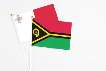 Vanuatu and Malta stick flags on white background. High quality fabric, miniature national flag. Peaceful global concept.White floor for copy space.