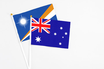 Fototapeta premium Australia and Marshall Islands stick flags on white background. High quality fabric, miniature national flag. Peaceful global concept.White floor for copy space.