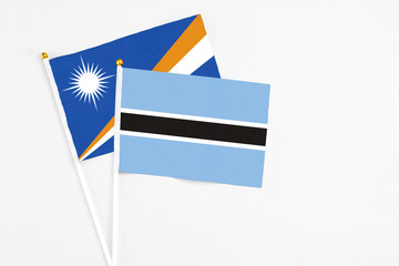 Botswana and Marshall Islands stick flags on white background. High quality fabric, miniature...
