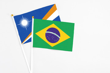 Brazil and Marshall Islands stick flags on white background. High quality fabric, miniature national flag. Peaceful global concept.White floor for copy space.