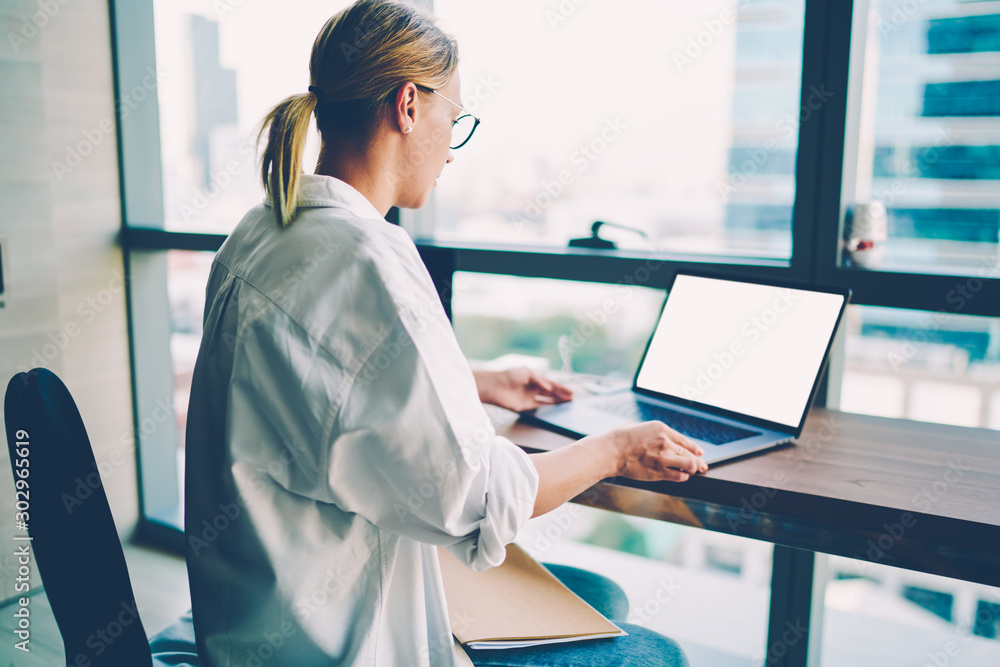 Aufkleber back view of creative female web designer in spectacles watching videos with new graphic ideas to im