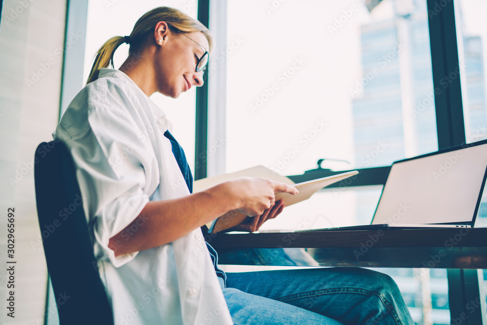 Aufkleber positive blonde student in optical spectacles reading notepad with study notes and preparing for sem
