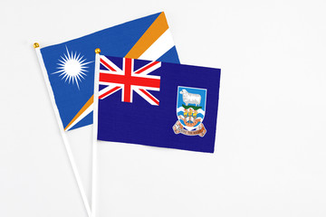 Falkland Islands and Marshall Islands stick flags on white background. High quality fabric,...