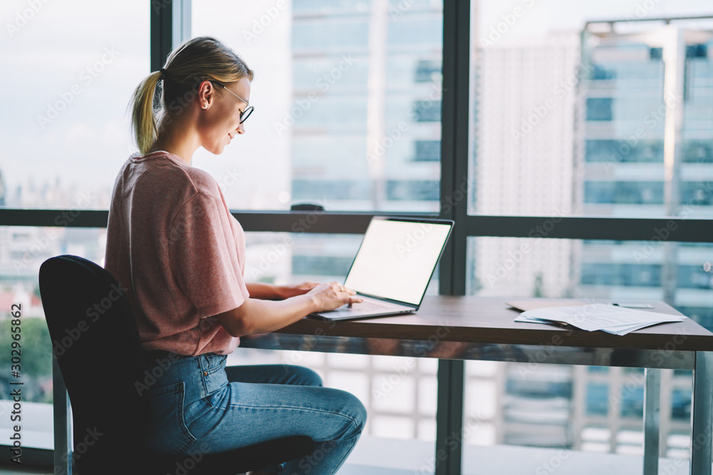 Aufkleber smiling female freelancer typing information on keyboard for uploading text matetial on internet web