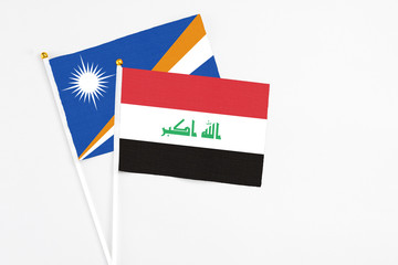 Iraq and Marshall Islands stick flags on white background. High quality fabric, miniature national...