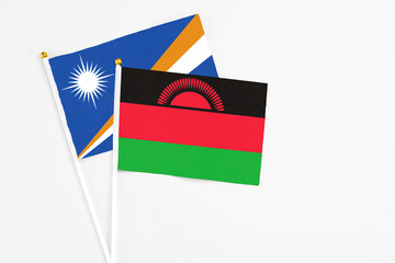 Malawi and Marshall Islands stick flags on white background. High quality fabric, miniature...