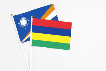 Mauritius and Marshall Islands stick flags on white background. High quality fabric, miniature national flag. Peaceful global concept.White floor for copy space.