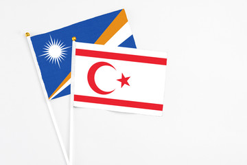 Northern Cyprus and Marshall Islands stick flags on white background. High quality fabric, miniature national flag. Peaceful global concept.White floor for copy space.