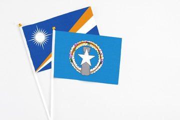 Northern Mariana Islands and Marshall Islands stick flags on white background. High quality fabric,...