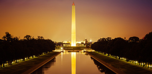 The Washington Monument at night with its image reflected in the National Mall reflecting pool. - obrazy, fototapety, plakaty