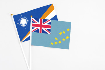 Tuvalu and Marshall Islands stick flags on white background. High quality fabric, miniature national flag. Peaceful global concept.White floor for copy space.