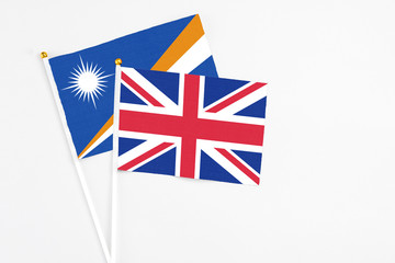 United Kingdom and Marshall Islands stick flags on white background. High quality fabric, miniature...