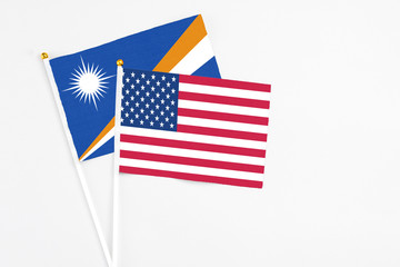 United States and Marshall Islands stick flags on white background. High quality fabric, miniature national flag. Peaceful global concept.White floor for copy space.