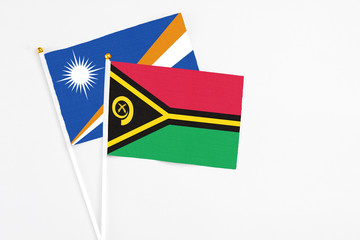 Vanuatu and Marshall Islands stick flags on white background. High quality fabric, miniature national flag. Peaceful global concept.White floor for copy space.