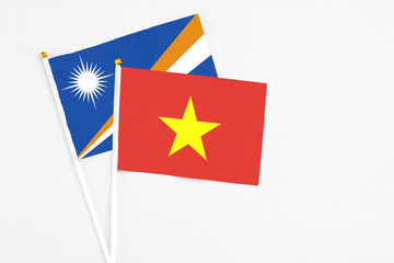 Vietnam and Marshall Islands stick flags on white background. High quality fabric, miniature national flag. Peaceful global concept.White floor for copy space.