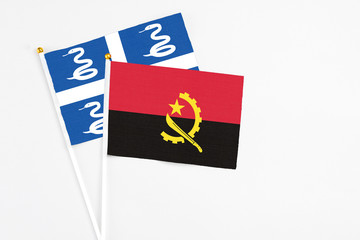 Angola and Martinique stick flags on white background. High quality fabric, miniature national flag. Peaceful global concept.White floor for copy space.