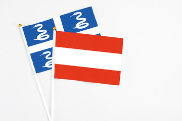 Austria and Martinique stick flags on white background. High quality fabric, miniature national flag. Peaceful global concept.White floor for copy space.