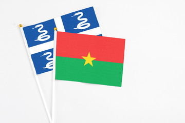 Burkina Faso and Martinique stick flags on white background. High quality fabric, miniature national flag. Peaceful global concept.White floor for copy space.