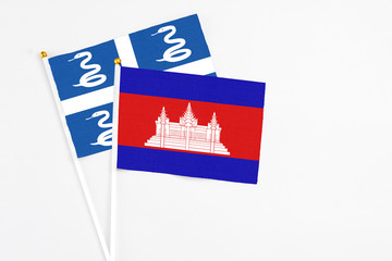 Cambodia and Martinique stick flags on white background. High quality fabric, miniature national flag. Peaceful global concept.White floor for copy space.