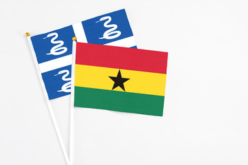 Ghana and Martinique stick flags on white background. High quality fabric, miniature national flag. Peaceful global concept.White floor for copy space.