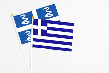 Greece and Martinique stick flags on white background. High quality fabric, miniature national flag. Peaceful global concept.White floor for copy space.