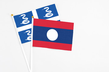Laos and Martinique stick flags on white background. High quality fabric, miniature national flag. Peaceful global concept.White floor for copy space.