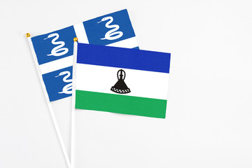 Lesotho and Martinique stick flags on white background. High quality fabric, miniature national...
