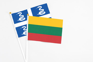 Lithuania and Martinique stick flags on white background. High quality fabric, miniature national flag. Peaceful global concept.White floor for copy space.