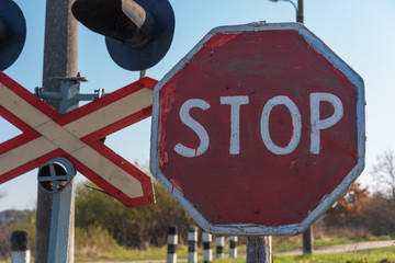 Non-regulated railway crossing in forest area with stop sign.