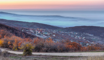 Village at sunset in the fog