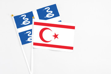 Northern Cyprus and Martinique stick flags on white background. High quality fabric, miniature national flag. Peaceful global concept.White floor for copy space.