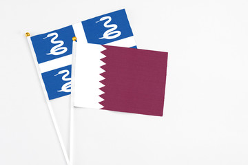 Qatar and Martinique stick flags on white background. High quality fabric, miniature national flag. Peaceful global concept.White floor for copy space.