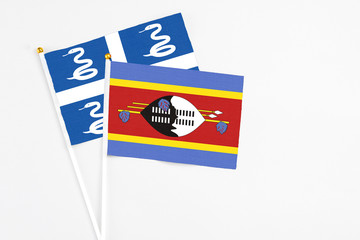 Swaziland and Martinique stick flags on white background. High quality fabric, miniature national flag. Peaceful global concept.White floor for copy space.