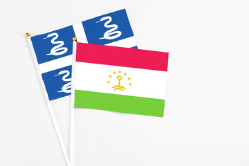 Tajikistan and Martinique stick flags on white background. High quality fabric, miniature national flag. Peaceful global concept.White floor for copy space.