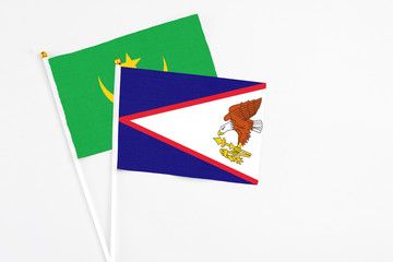American Samoa and Mauritania stick flags on white background. High quality fabric, miniature national flag. Peaceful global concept.White floor for copy space.